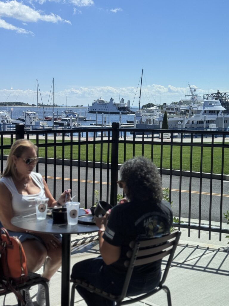 Guests dining on the Frenchies Coffee Bar patio overlooking the Steelpointe Harbor marina in Bridgeport, CT